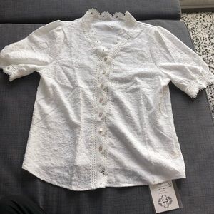 White blouse with high lacy collar and rose gold buttons